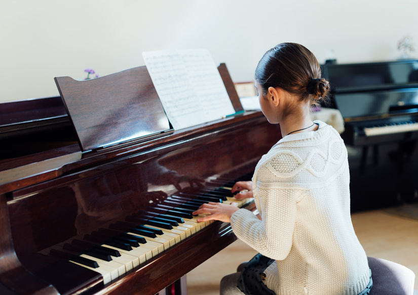girl playing grand piano